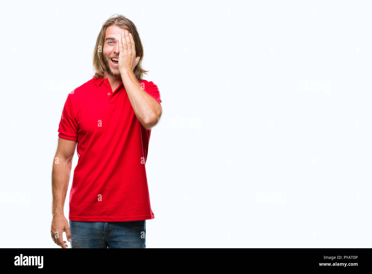 Young handsome man with long hair over isolated background covering one ...