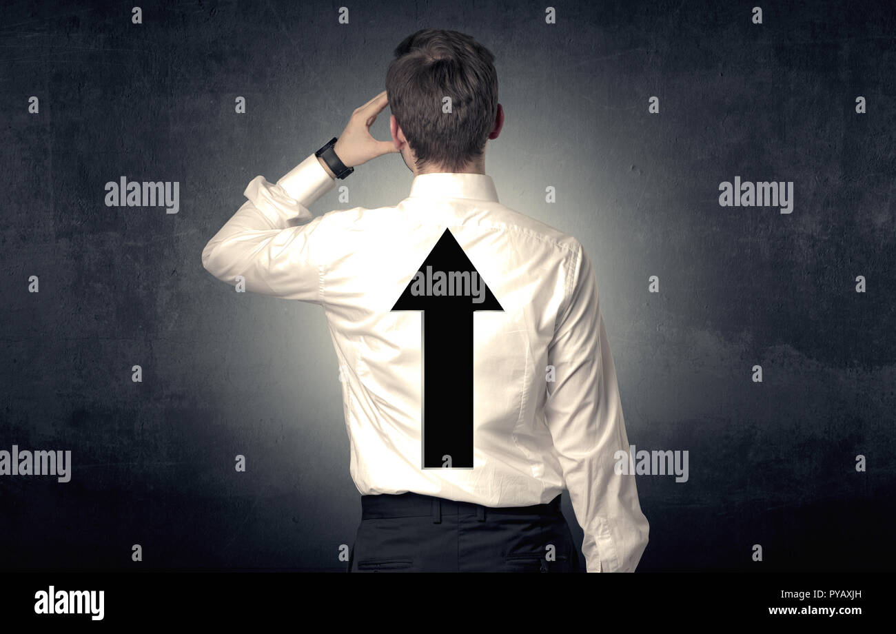 Young businessman standing and thinking about which direction to choose ...