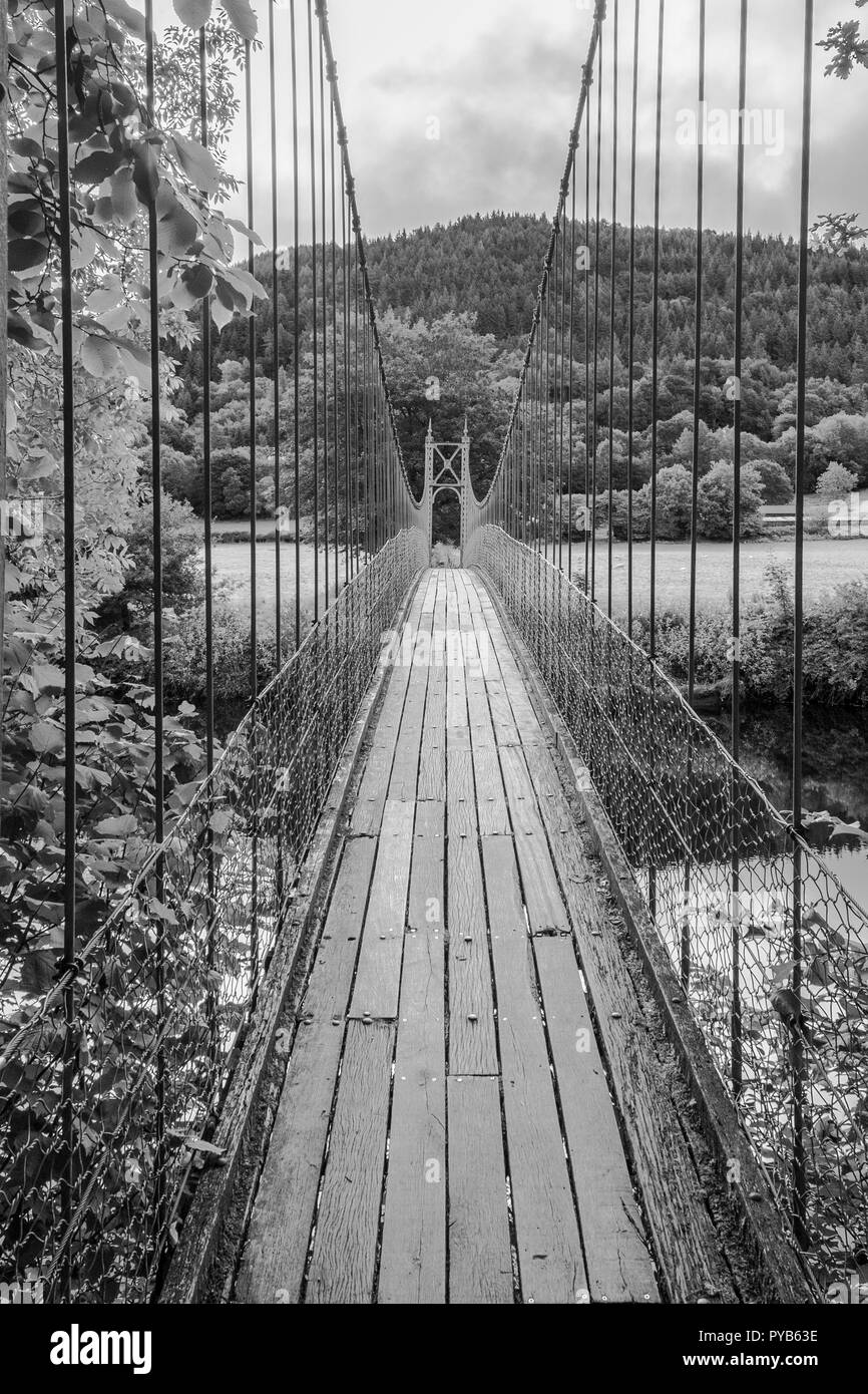 Sappers suspension bridge over the River Conwy built in 1930 and a prominent landmark in the village of Betws-y-Coed in North Wales. In Black and Whit Stock Photo