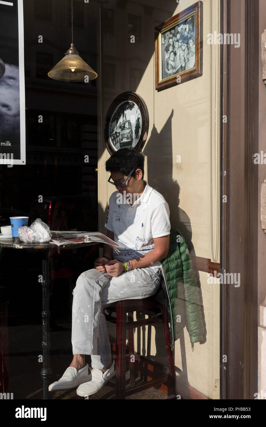 A man sits in the sunlit window of a central London cafe, on 25th October 2018, in Piccadilly, London, England. Stock Photo