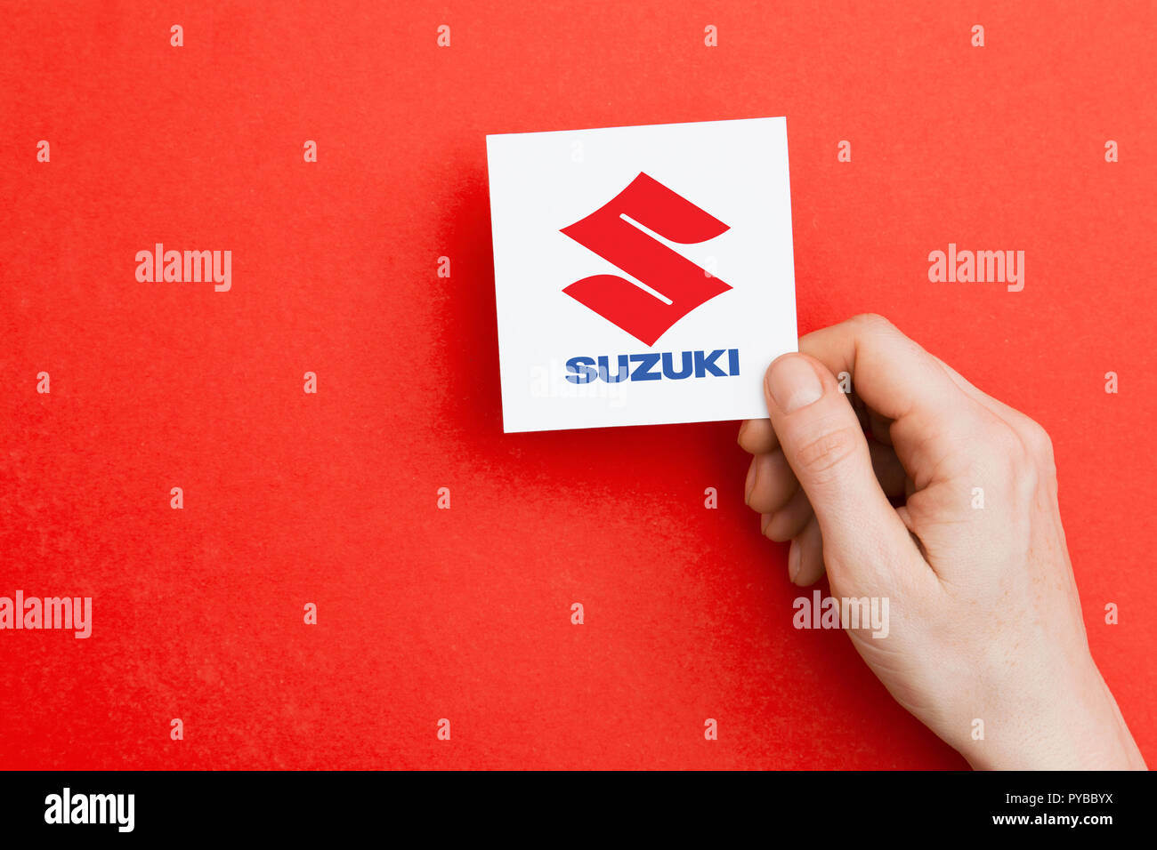 LONDON, UK - October 26th 2018: Hand holding a Suzuki logo. Suzuki is an automobile manufacturer. Stock Photo