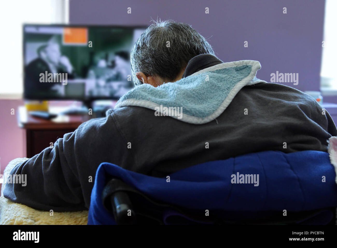 New York, NY USA. Jun 2016. Elderly man asleep in front of the TV at a nursing home. Stock Photo