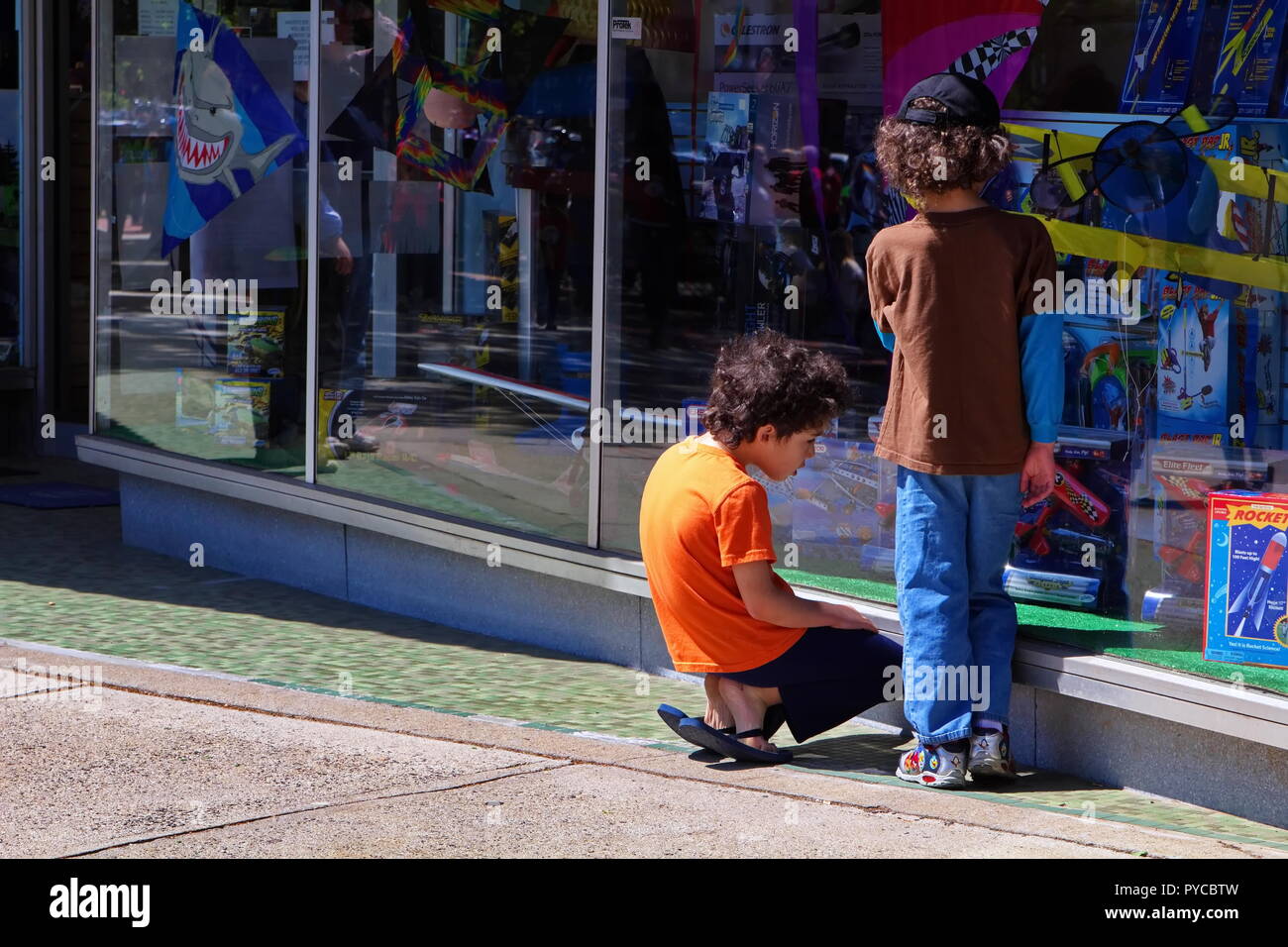 Middletown, CT USA. May 2013. Two boys decided to pay more attention to the toy store rather than the Memorial Day parade going on. Stock Photo