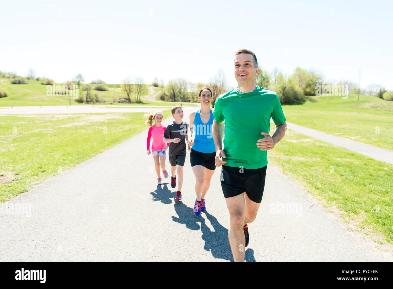 Parents with children sport running together outside Stock Photo