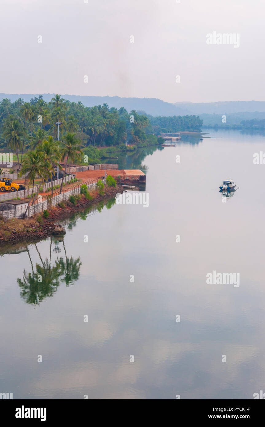 Here you can see the motorboat near the pier, parked excavator on the  beach, smoke from the fireplace rather far off and other Indian waterfront  lifes Stock Photo - Alamy