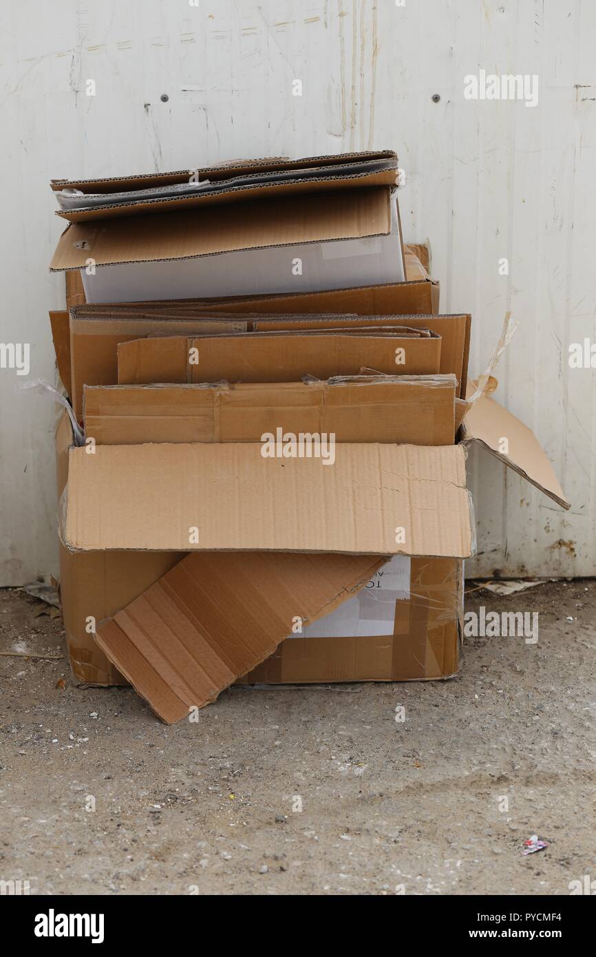 Paper Boxes Waste on the Pavement. Stack of paper boxes waste folded and stackedon the sidewalk. Used moving Boxes, Old carton, Shipping Boxes. Stock Photo