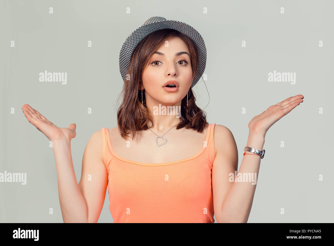 Portrait dumb looking woman arms out shrugs shoulders I don't know isolated on loght gray wall background. Negative human emotion, facial expression b Stock Photo