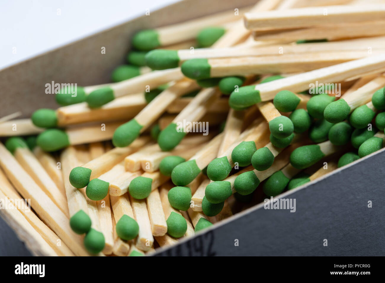 Box full of pile of matches with green heads. Up close macro shot Stock
