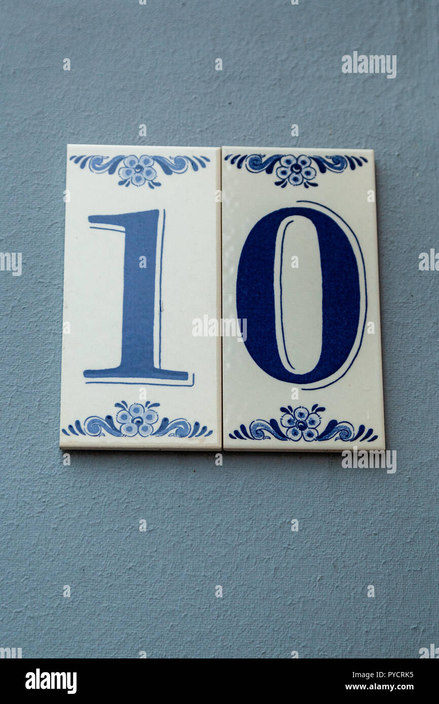 House number ten 10 painted on ceramic tile in blue with flowers from Sweden Stock Photo