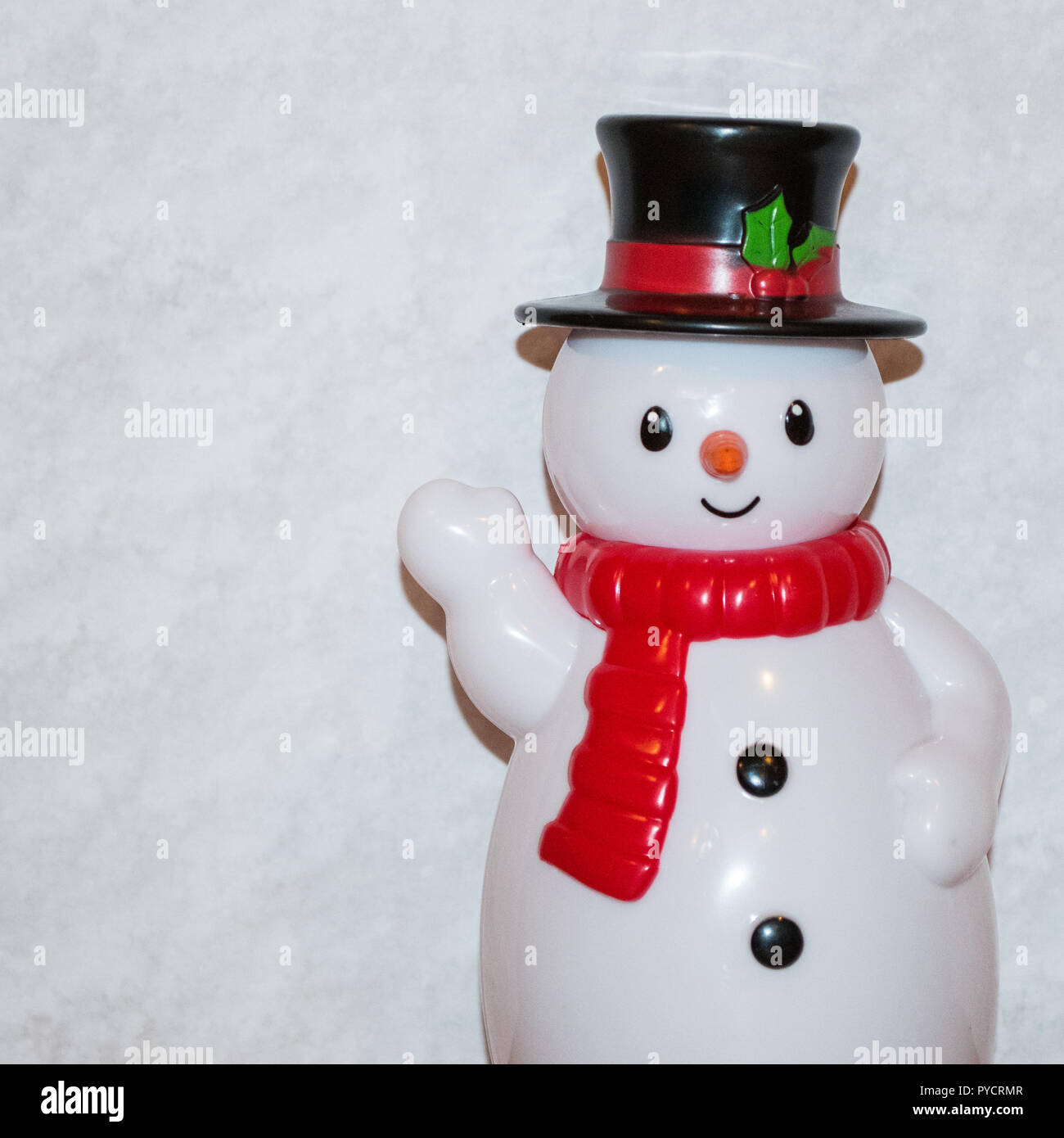 Toy snowman waving with white scarf and 