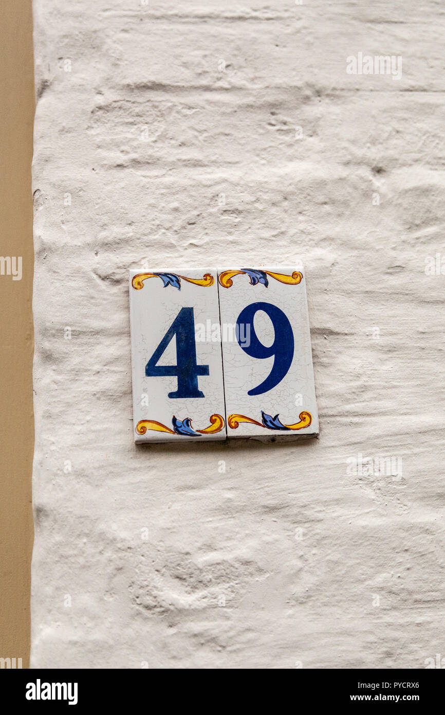 House number forty-ine 49 painted on ceramic tile in blue and yellow, red and gold from Sweden Stock Photo