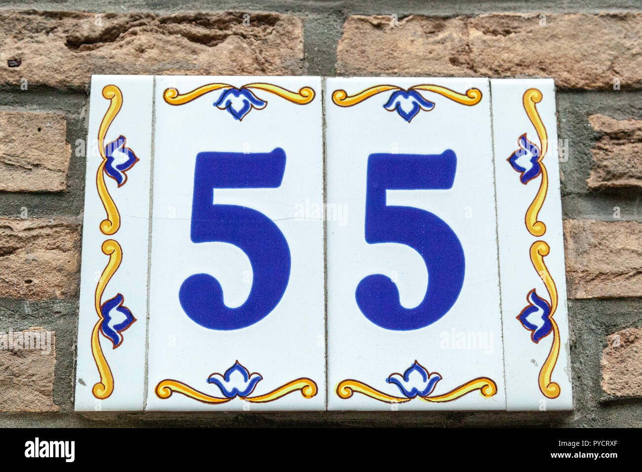 House number fifty-five 55 painted on ceramic tile in blue and yellow, red and gold from Sweden Stock Photo