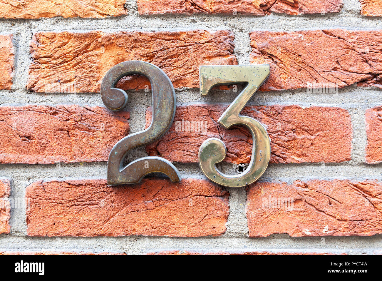 House numbertwenty-three 23 in cast metal, polisehed brass weathered in gothic designer font from Sweden Stock Photo