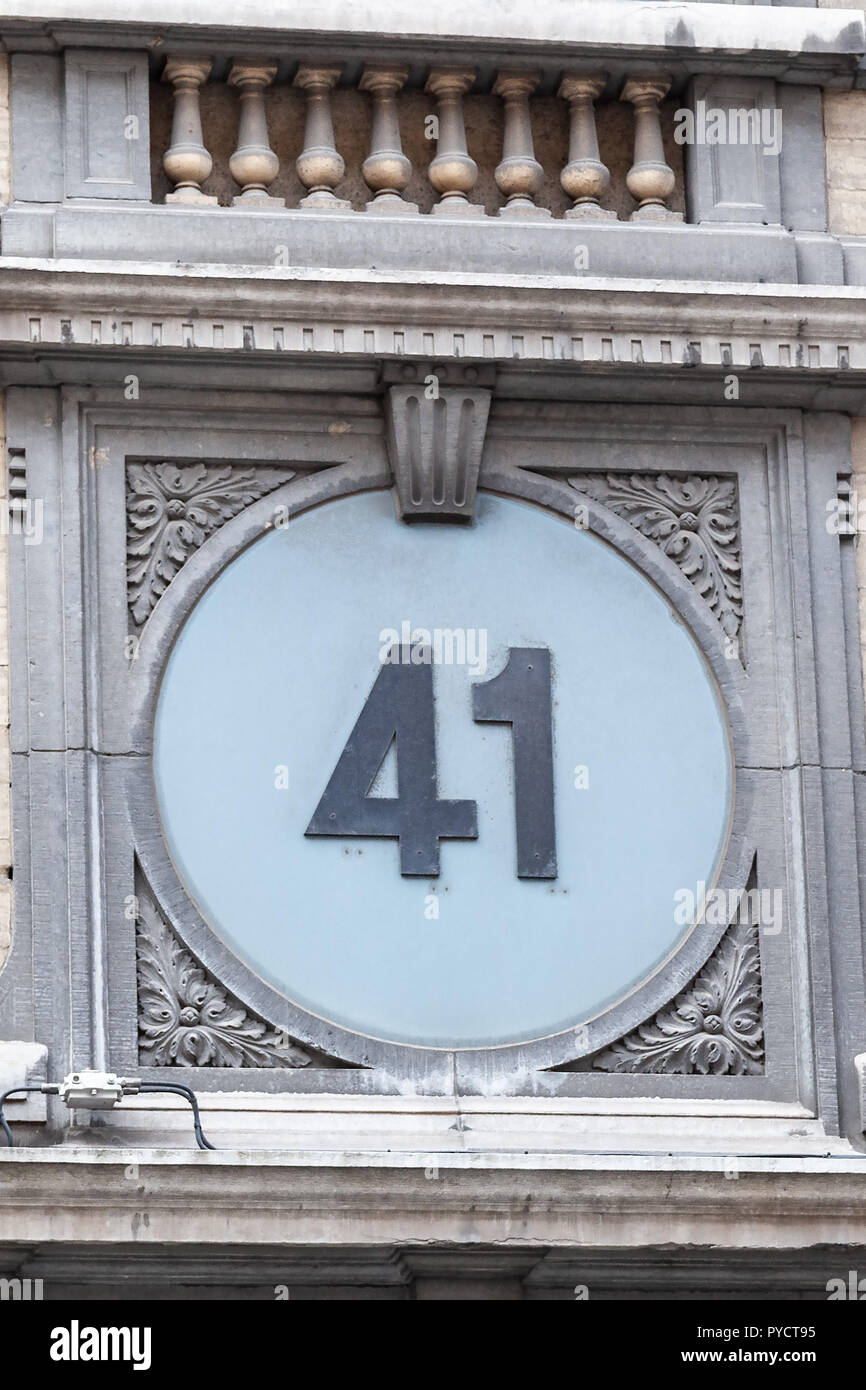 House number forty-one 41 in cut out metal, painted black on baby blue background in circle frame of concrete emblems from Sweden Stock Photo