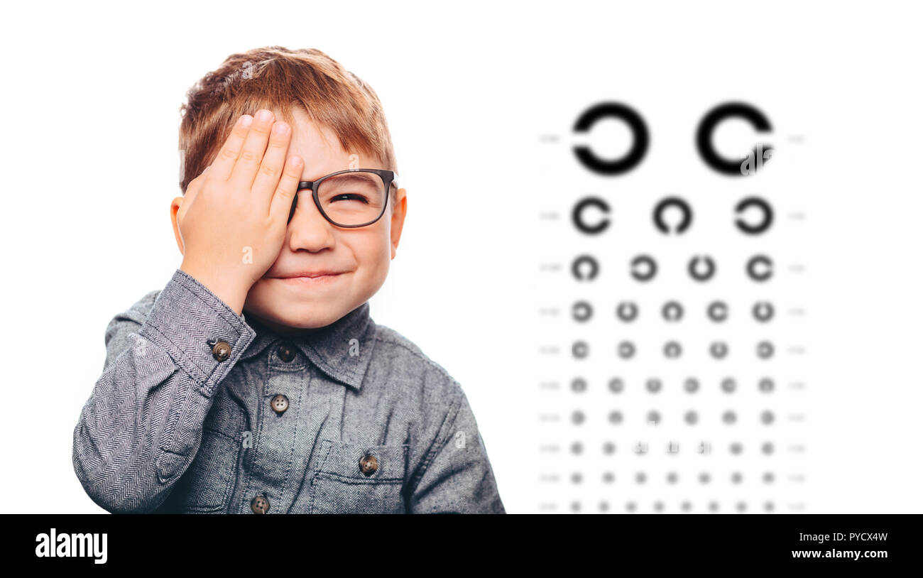 boy having eye exam with eye chart and covering one eye Stock Photo Alamy