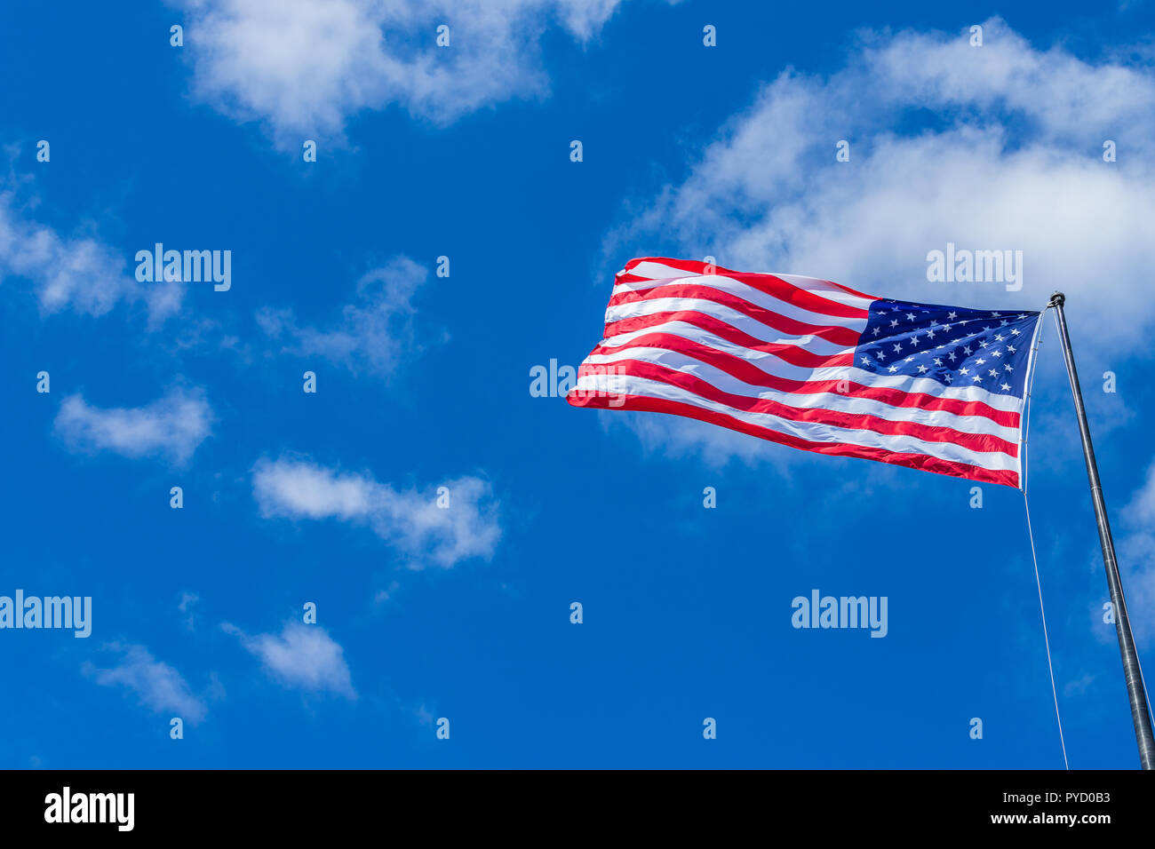 American Flag waving with cloudy blue sky on a sunny day Stock Photo ...