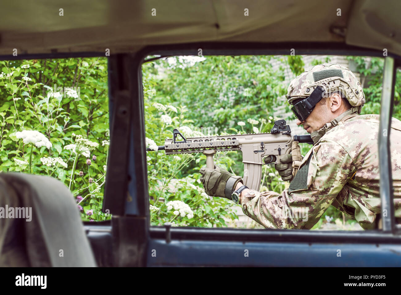 Military man sniper with automatic rifle aims into the distance - view ...