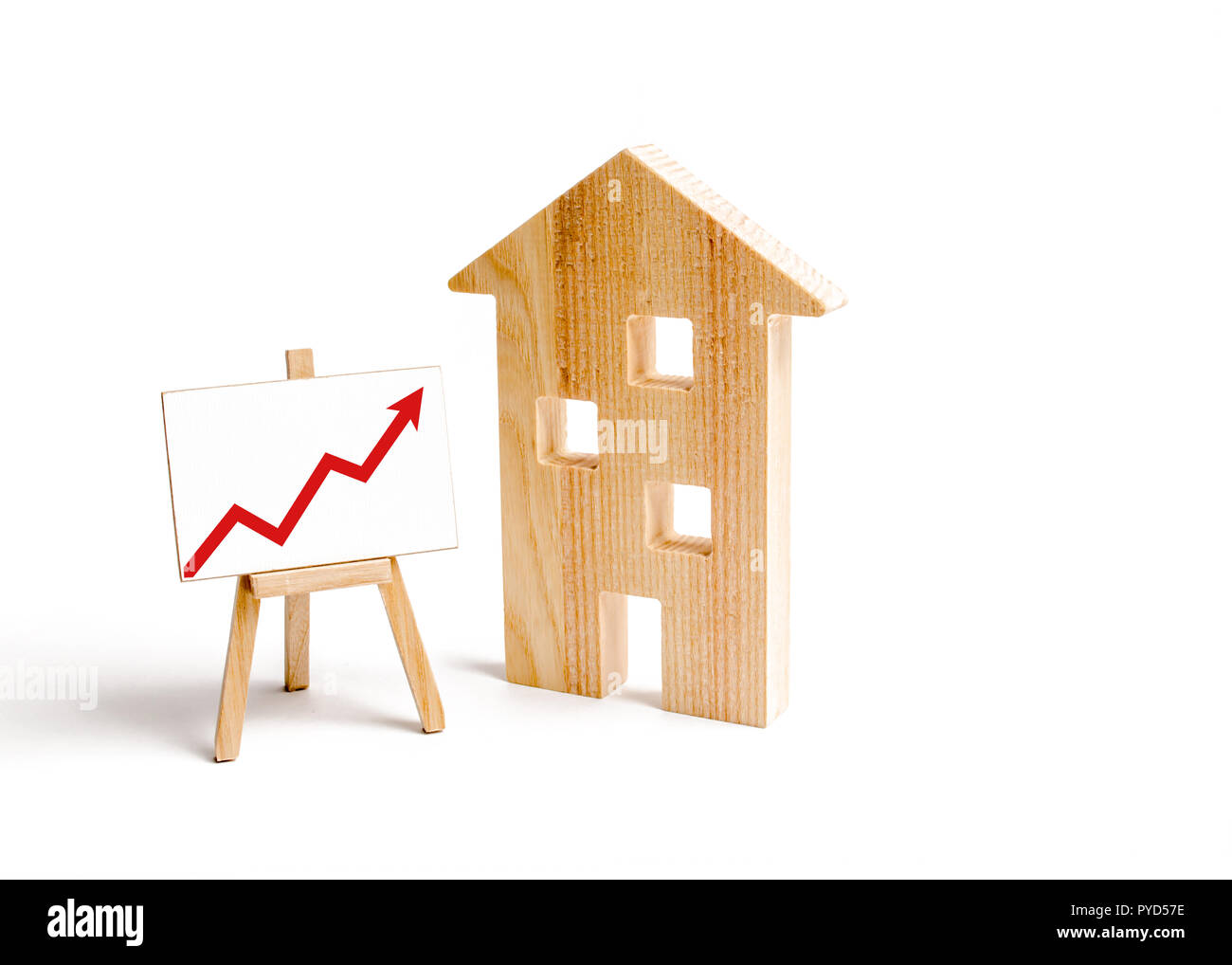 Wooden houses and stand with red arrow up. Growing demand for housing and real estate. The growth of the city and its population. Investments. concept Stock Photo