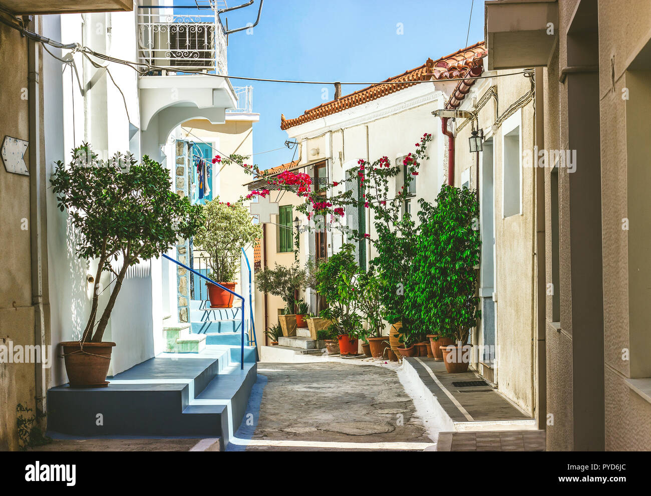 Narrow streets of Neorio town in Poros island, Greece;  Old white houses with flowers Stock Photo