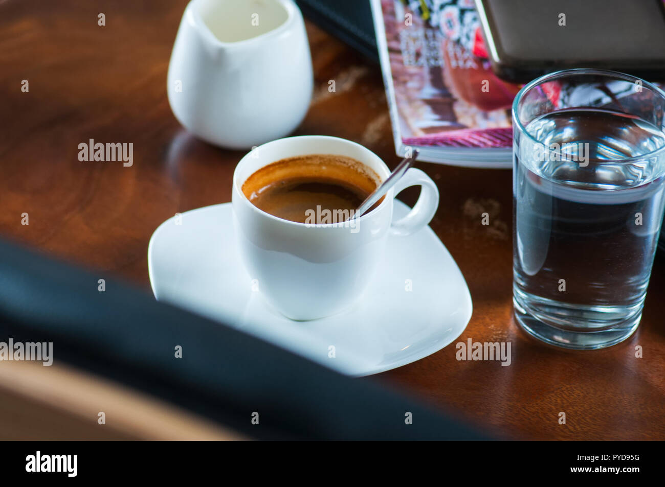 Espresso set, smart phone, magazines on a working table. Break t Stock Photo