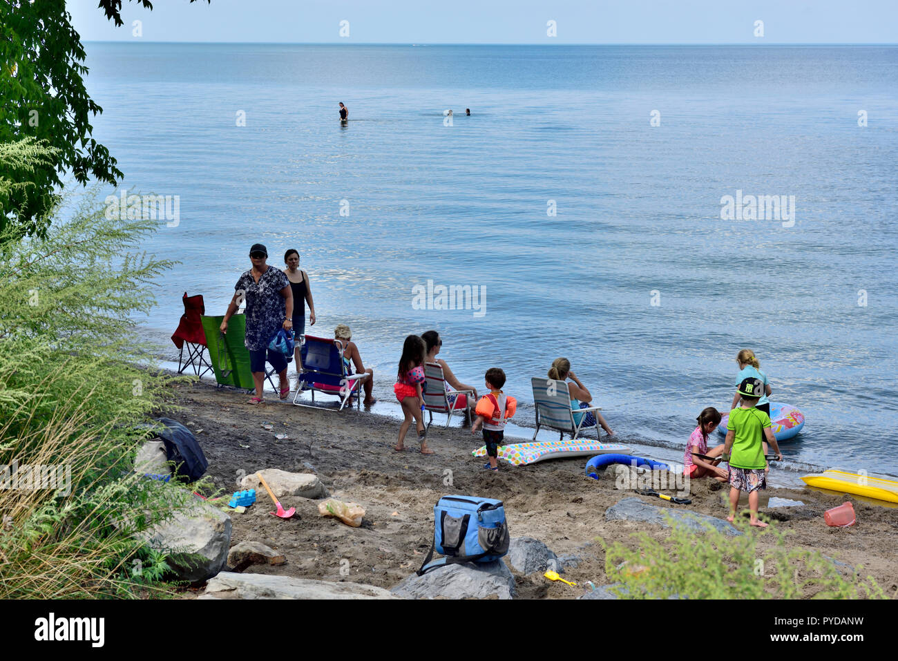 People playing on small beach and in water of  Lake Ontario, New York State, USA Stock Photo