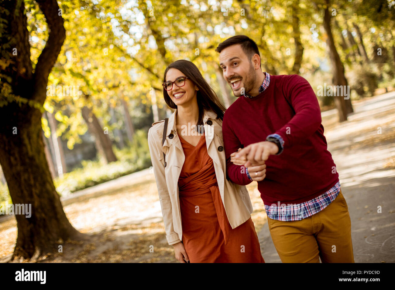 Loving young woman and man walking in city park holding hands Stock ...