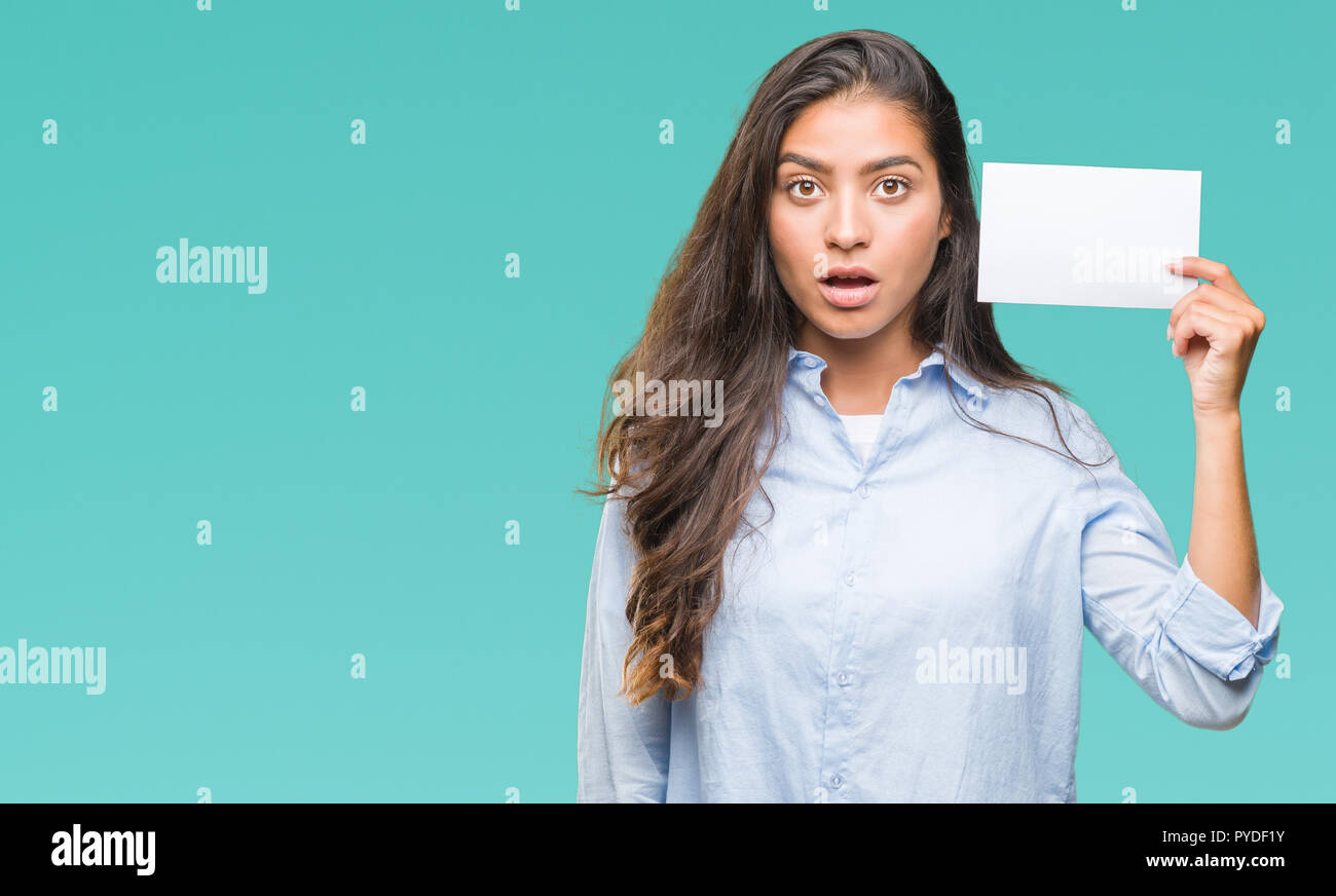 young arab woman holding blank card over isolated background