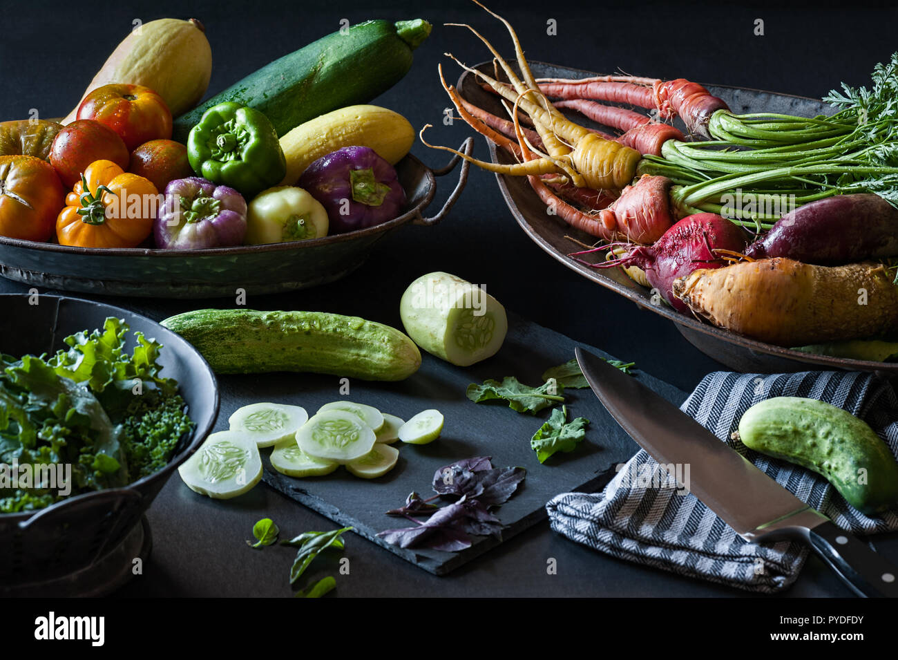 A still life of fresh summer produce from the garden including cucumber, carrots, peppers and more. Stock Photo