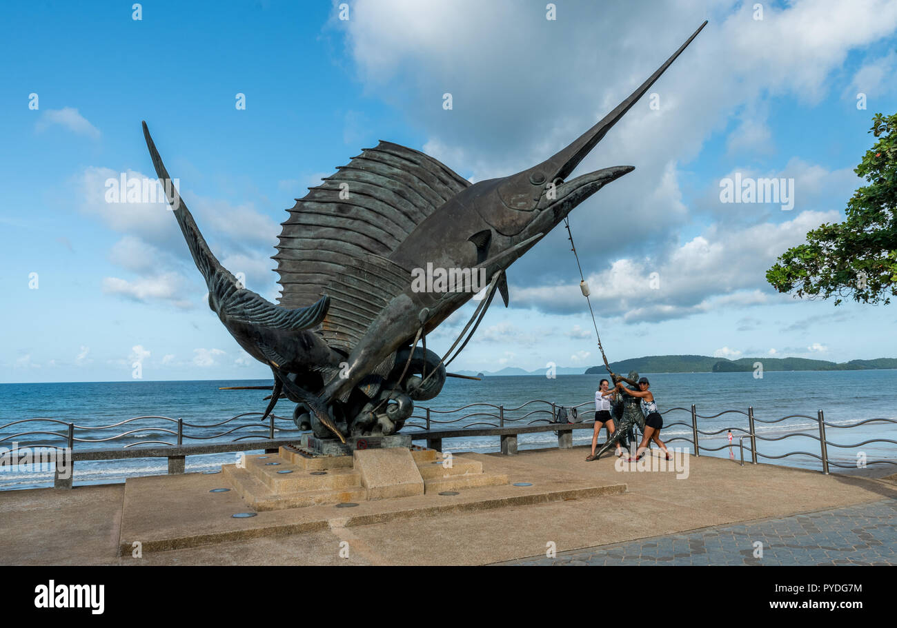 Ao Nong, Thailand-August 2, 2018:Mother and daughter playing with statue of fish Stock Photo