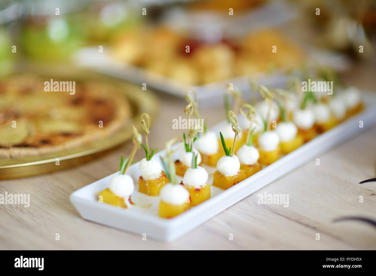 Delicious baked pineapple and mozzarella mini snacks served on a party ...