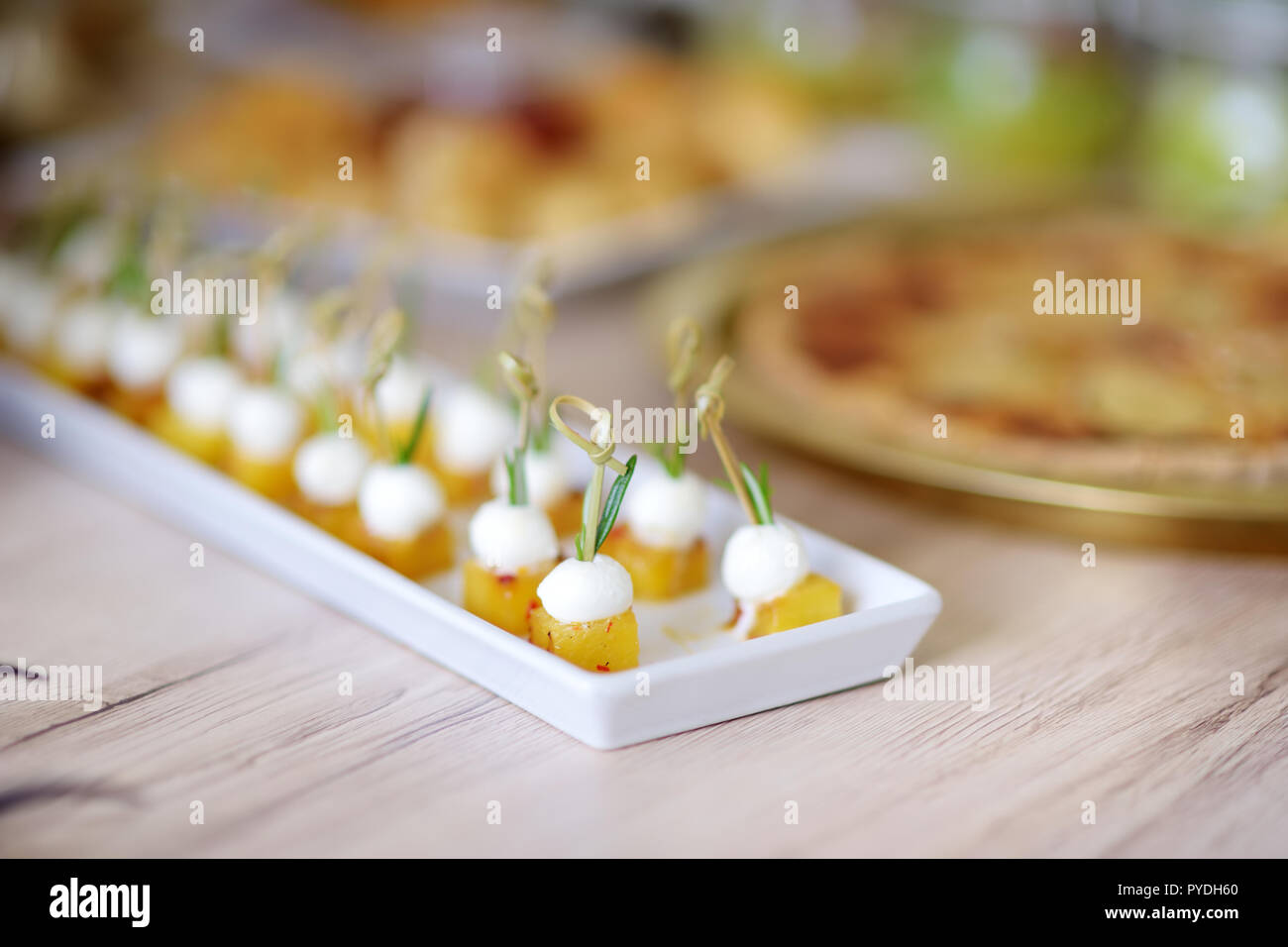 Delicious baked pineapple and mozzarella mini snacks served on a party ...
