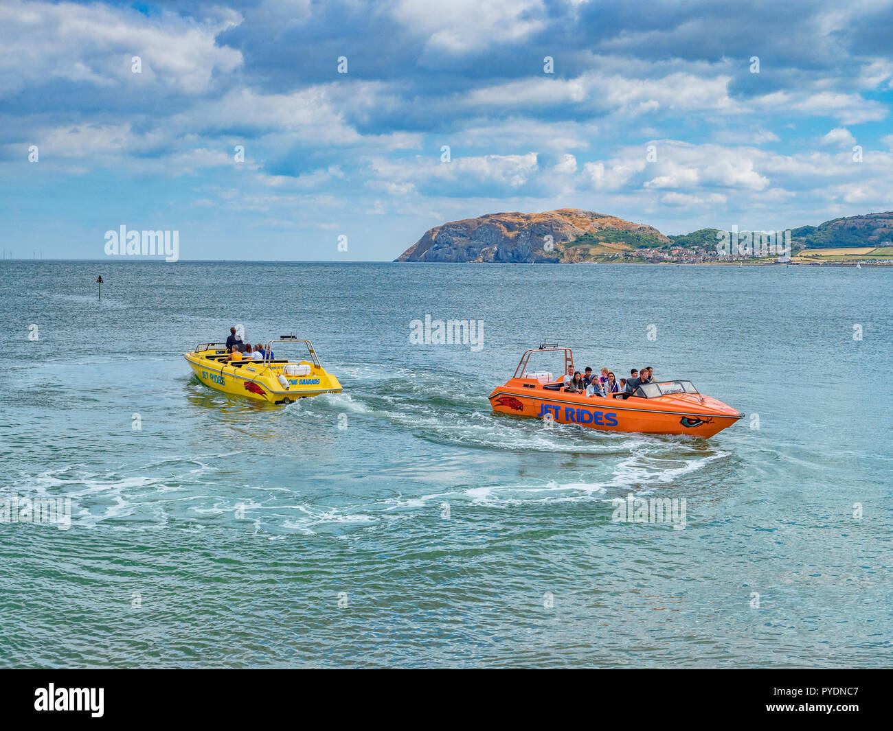 15 July 2018: Llandudno, Conwy, UK - Jet boat rides in the bay, with the Little Orme in the background. Stock Photo