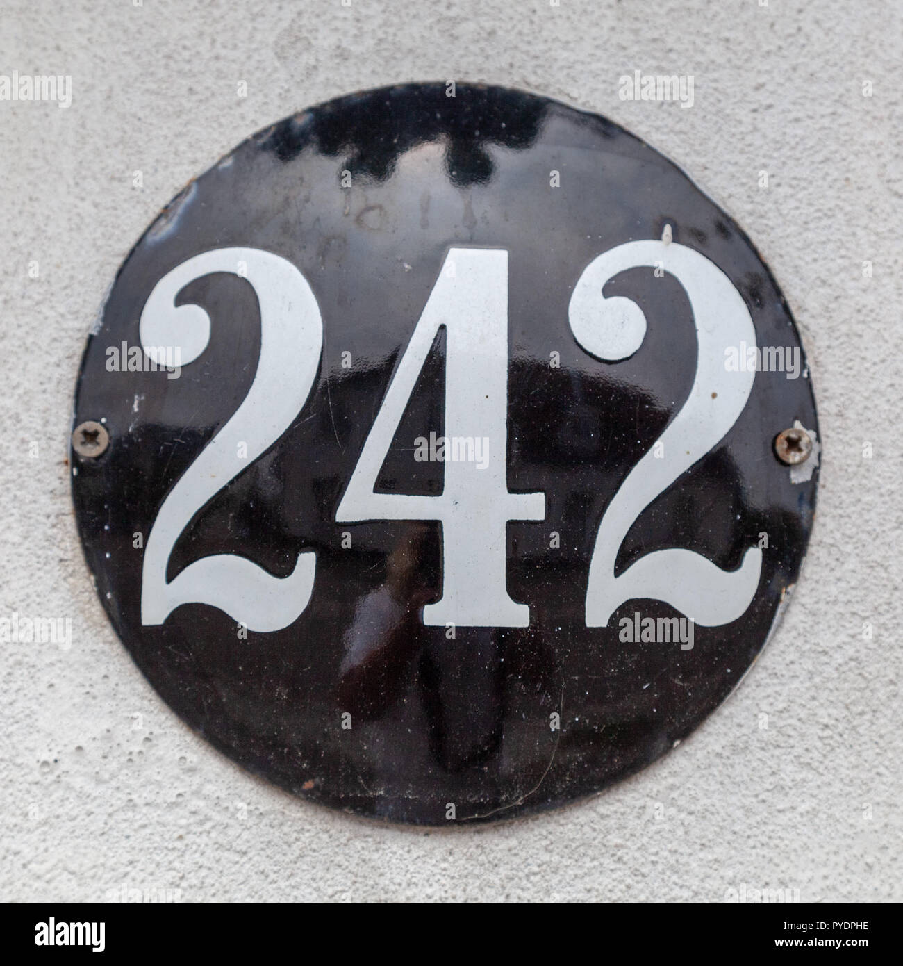House number two hundred and forty-two 242 on enamel plaque in black and white from Sweden Stock Photo