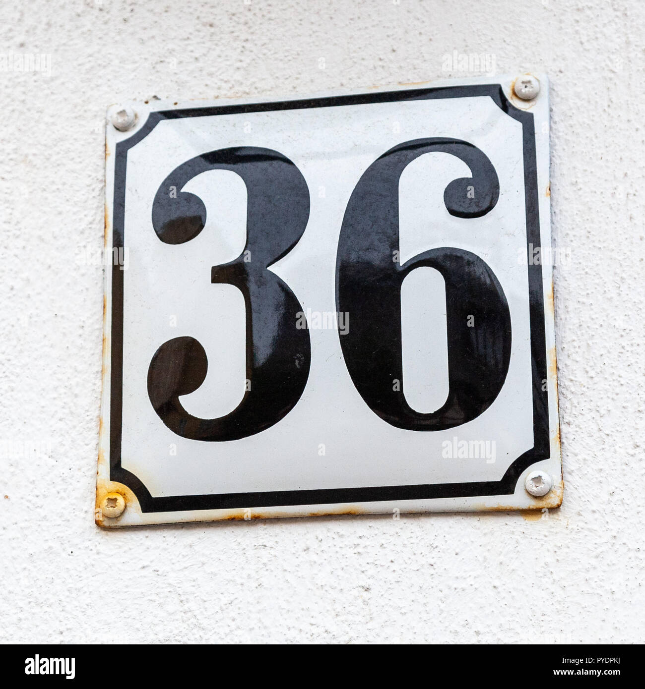 House number thirty-six 36 on enamel plaque in black and white from Sweden Stock Photo