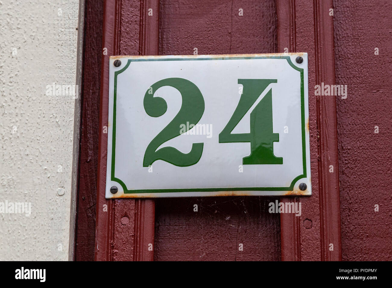 House number twenty-four 24 on enamel plaque in green and white from Sweden Stock Photo