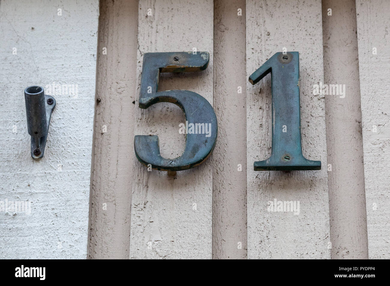 House number fifty-one 51 in designer font in cast polished metal, brass looking weathered or tarnished from Sweden Stock Photo