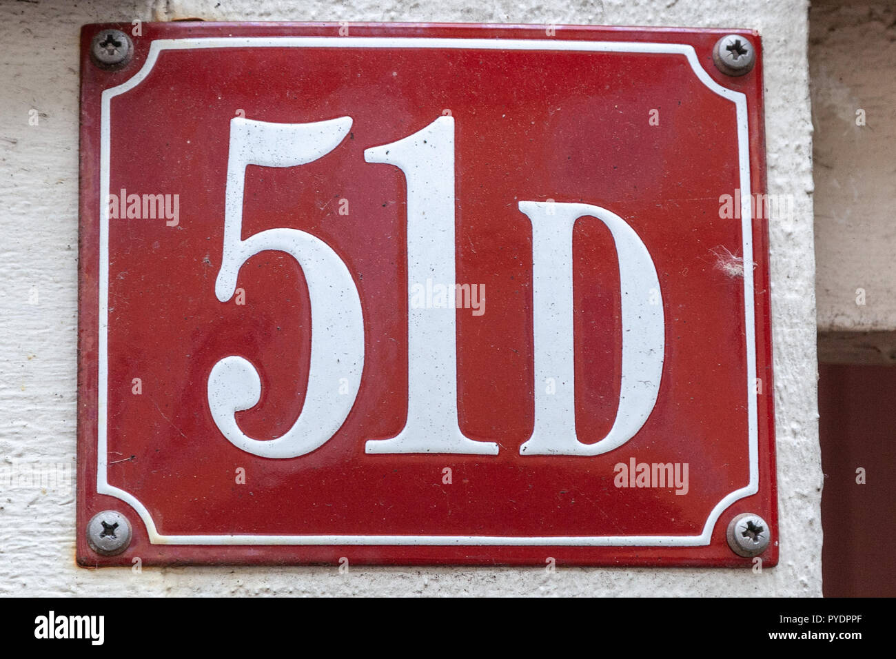 House number fifty-one D 51D on enamel plaque in white on red background from Sweden Stock Photo