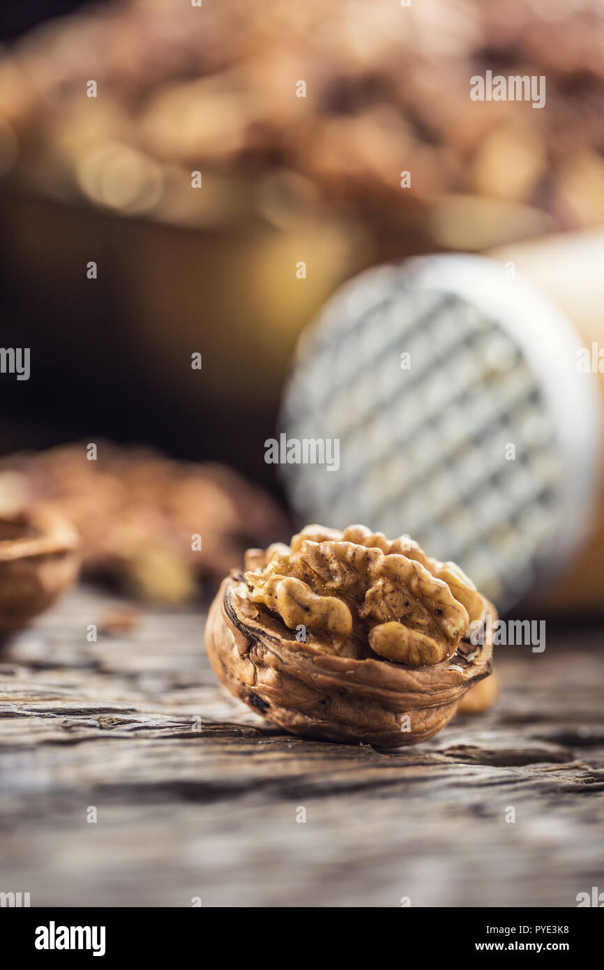 Close-up walnut kernel and whole walnuts on old wooden table. Stock Photo