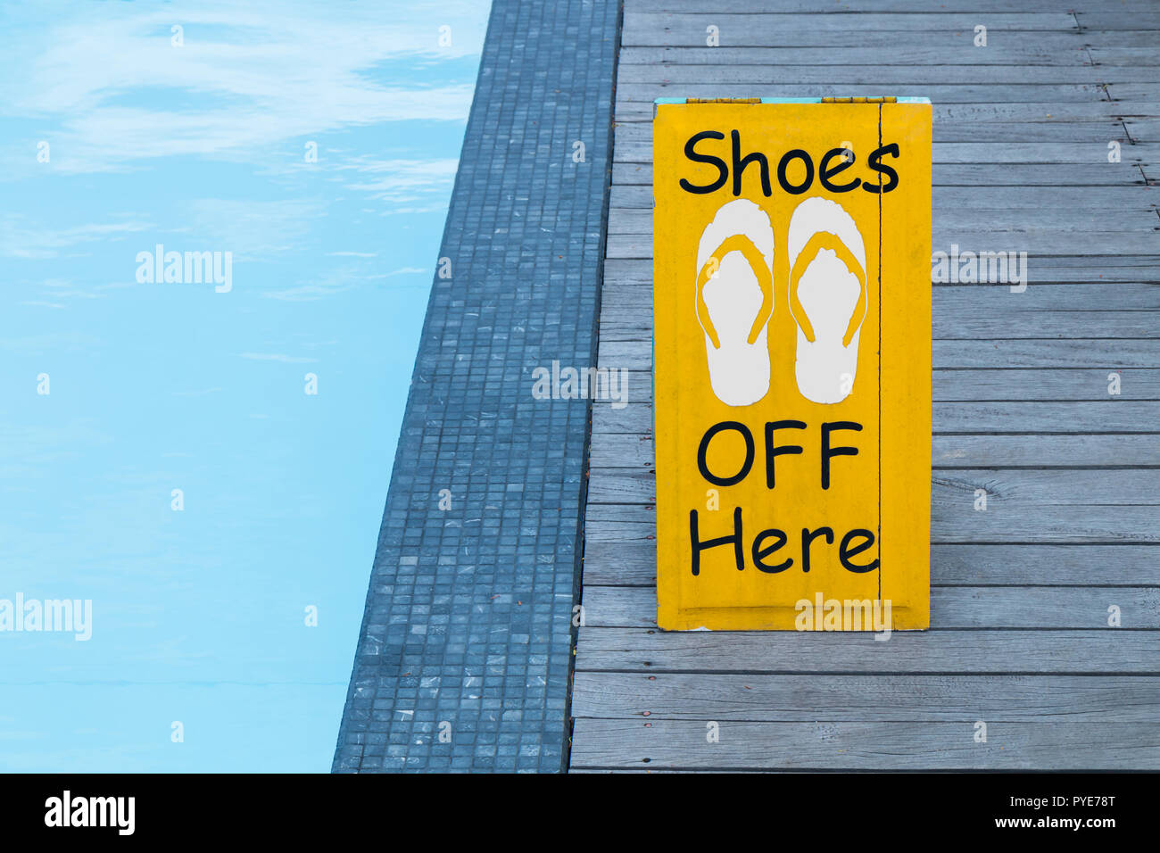 No shoes sign by the swimming pool on the wooden floor in yellow color Stock Photo
