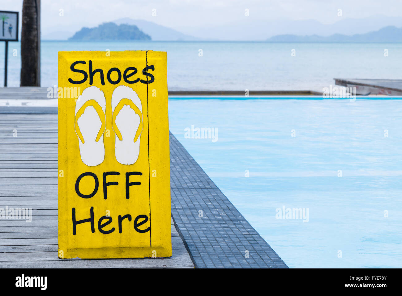 No shoes sign by the swimming pool on the wooden floor in yellow color Stock Photo