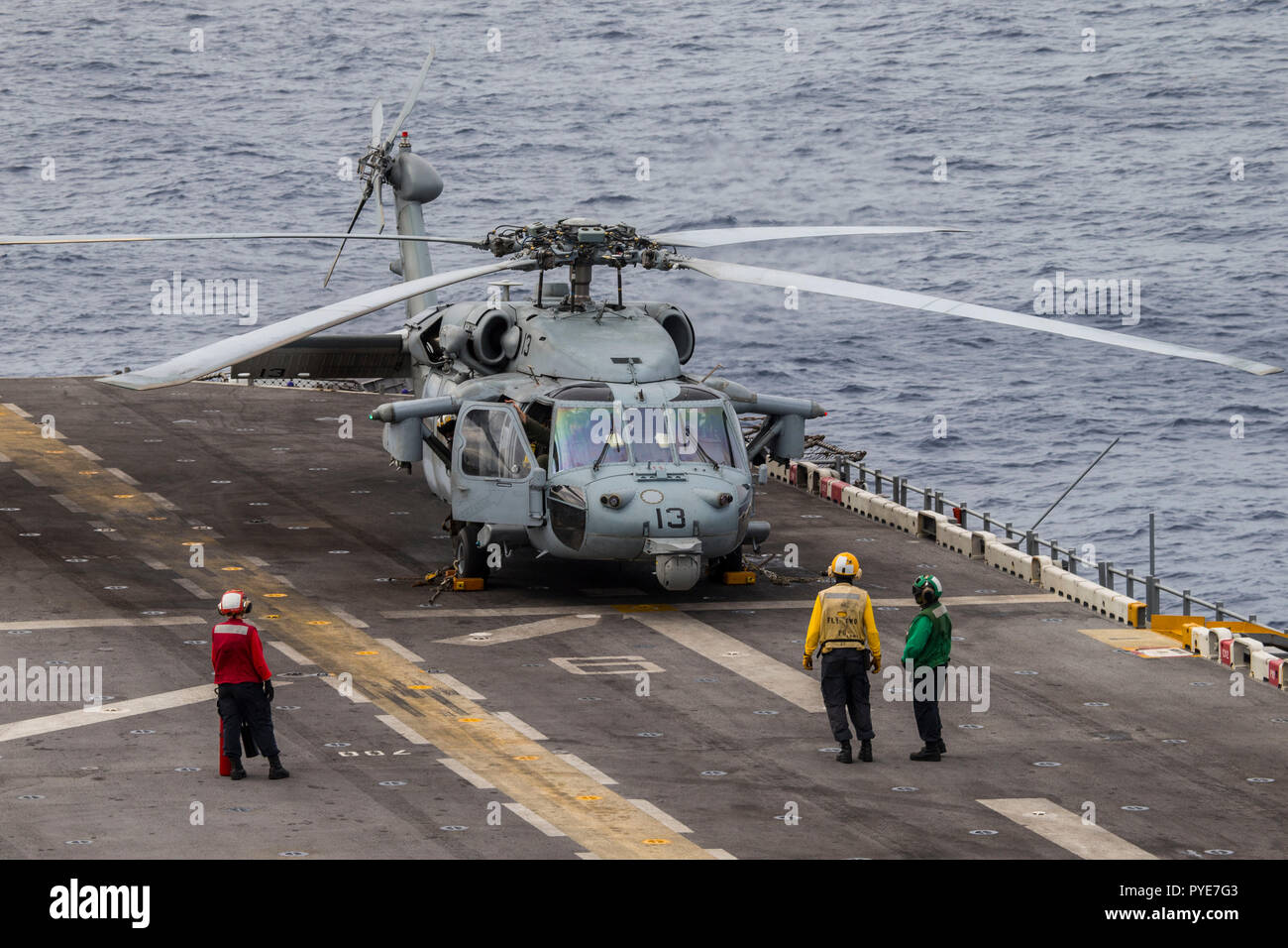 Sailors watch as a MH-60S Sea Hawk with Marine Medium Tiltrotor Squadron 264 (Reinforced) prepares to take flight during Carrier Strike Group (CSG) 4 composite training unit exercise (COMPTUEX) aboard the Wasp-class amphibious assault ship USS Kearsarge (LHD 3), Oct. 23, 2018. COMPTUEX is the final pre-deployment exercise that certifies the combined Kearsarge Amphibious Ready Group (ARG) and 22nd Marine Expeditionary Unit's abilities to conduct military operations at sea and project power ashore through joint planning and execution of challenging and realistic scenarios. (U.S. Marine Corps pho Stock Photo