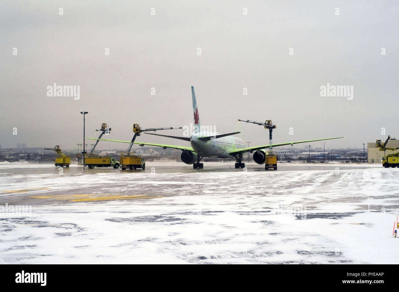 Planes are lining up on the snowy runway in Toronto airport (YYZ), the biggest de-icing station in the world, to get treated before take off. Stock Photo