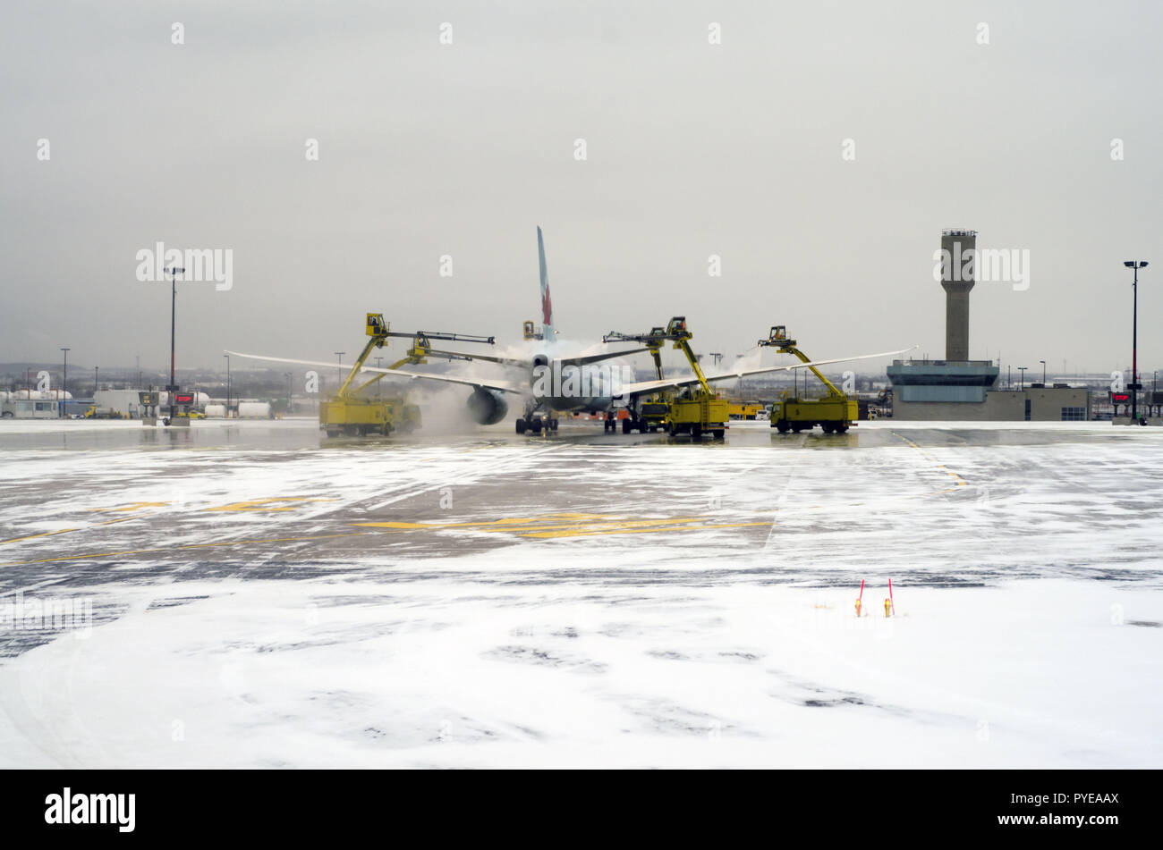Planes are lining up on the snowy runway in Toronto airport (YYZ), the biggest de-icing station in the world, to get treated before take off. Stock Photo
