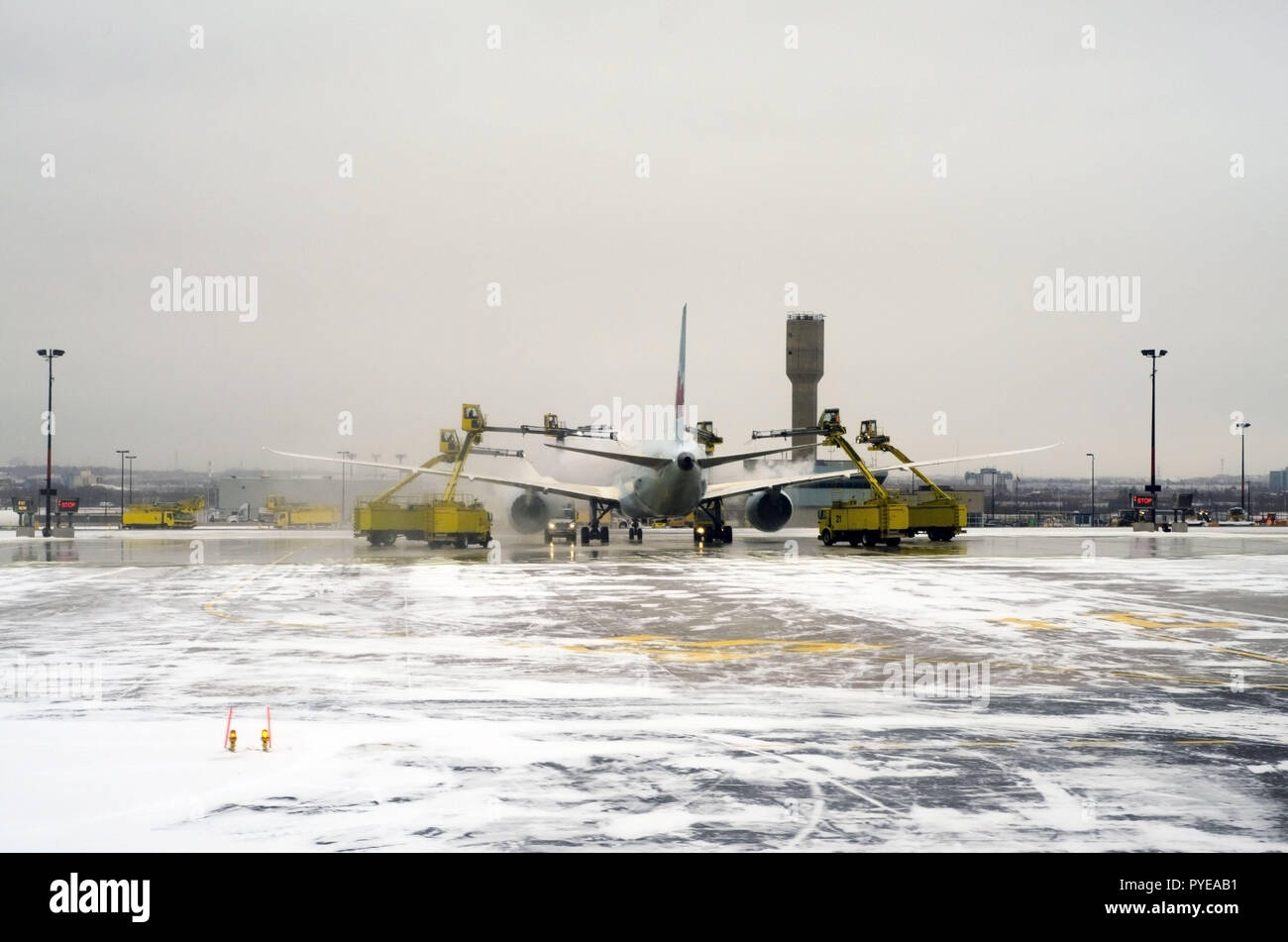 Planes are lining up on the snowy runway in Toronto airport (YYZ), the biggest de-icing station in the world, to get treated before take off. Stock Photo