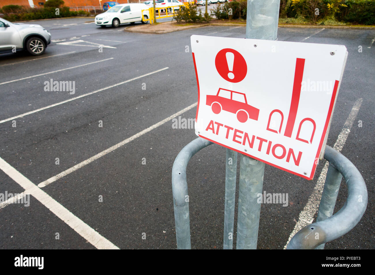 Warning sign on circular barrier to stop cars from hitting a lamp post in a supermarket car park, Durham , County Durham UK Stock Photo