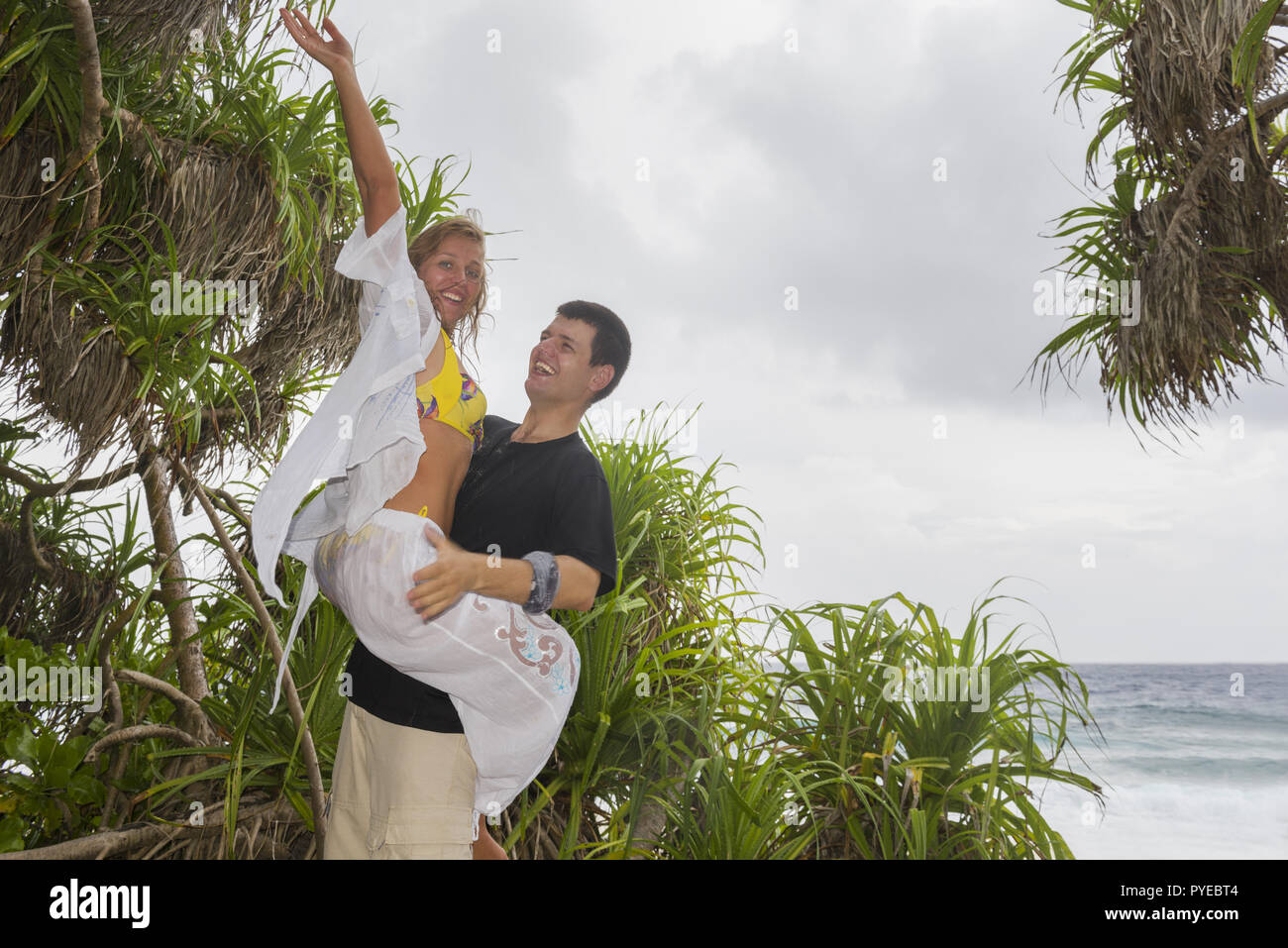 Happy young couple on a beautiful tropical beach. Honeymoon on an exotic island. Honeymoon beautiful couple on an exotic beach. Couple in love travel  Stock Photo