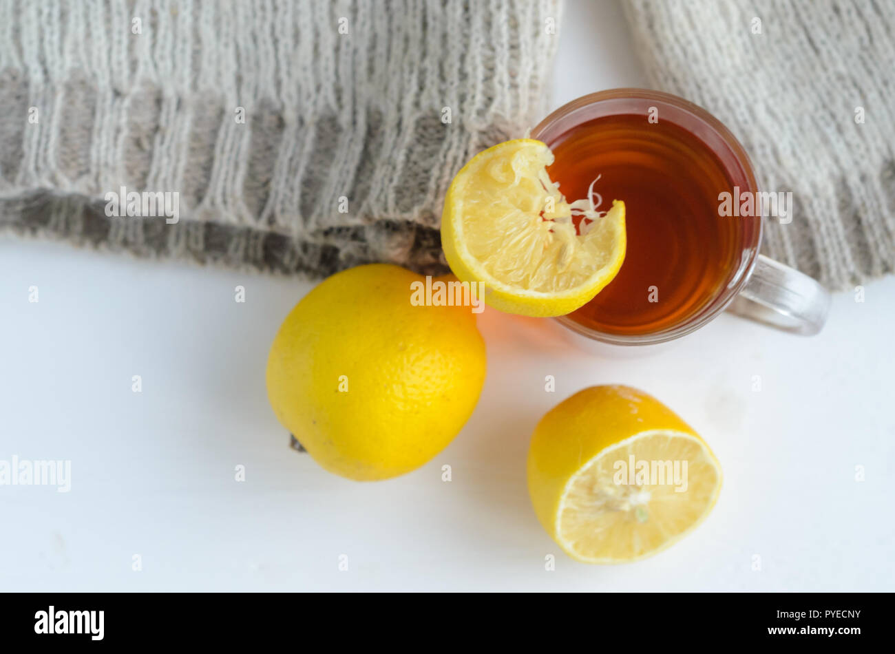 cup of tea with lemon , one and half lemon and woolen sweater. Stock Photo