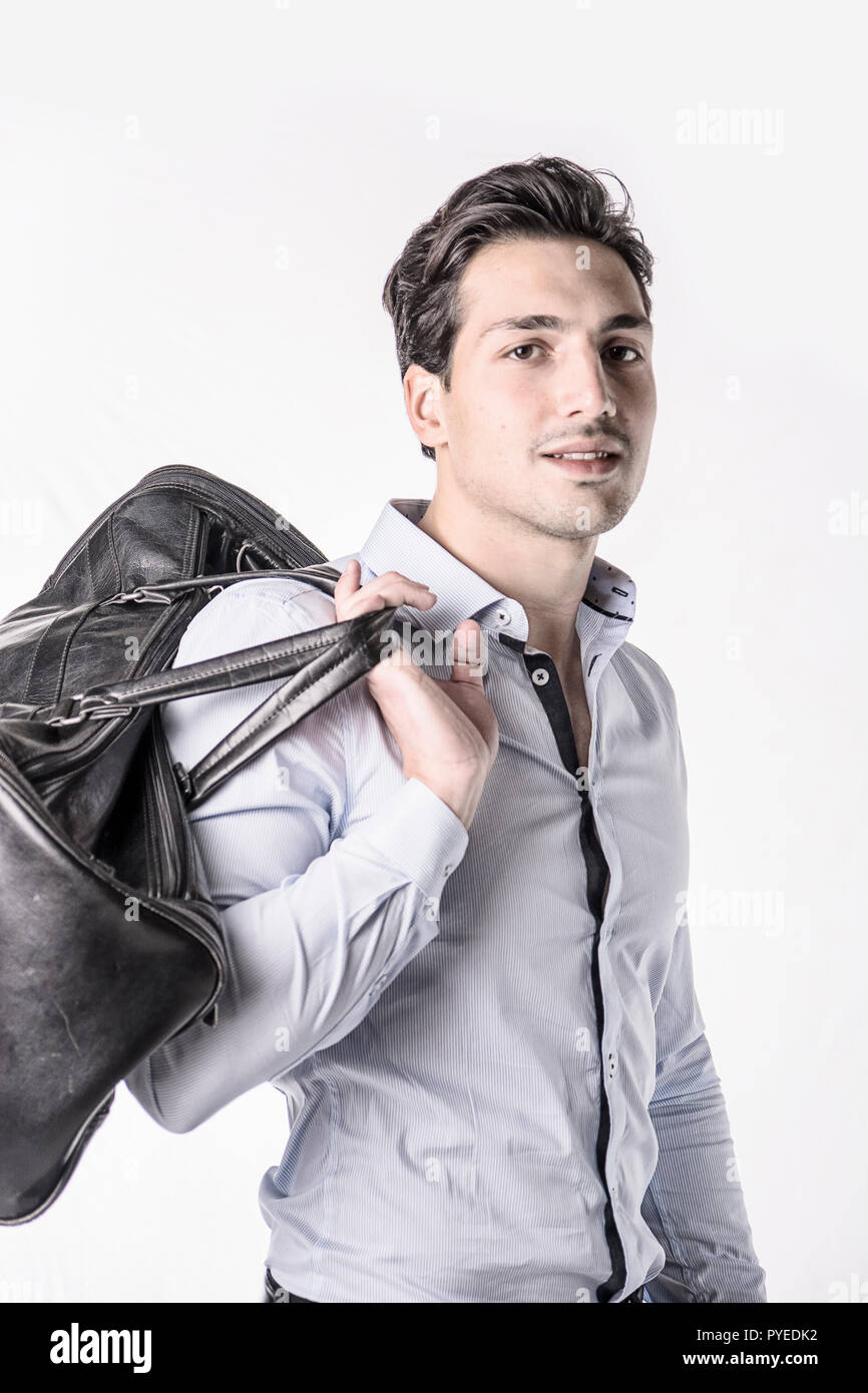 Young attractive man on white background carrying big black leather bag  over shoulder Stock Photo - Alamy