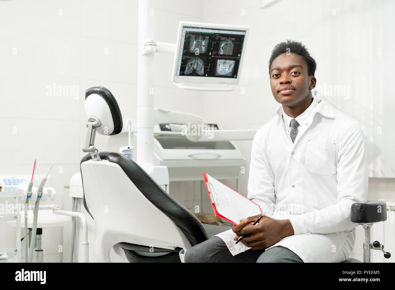 Young African American male doctor dentist in dental office. Medicine