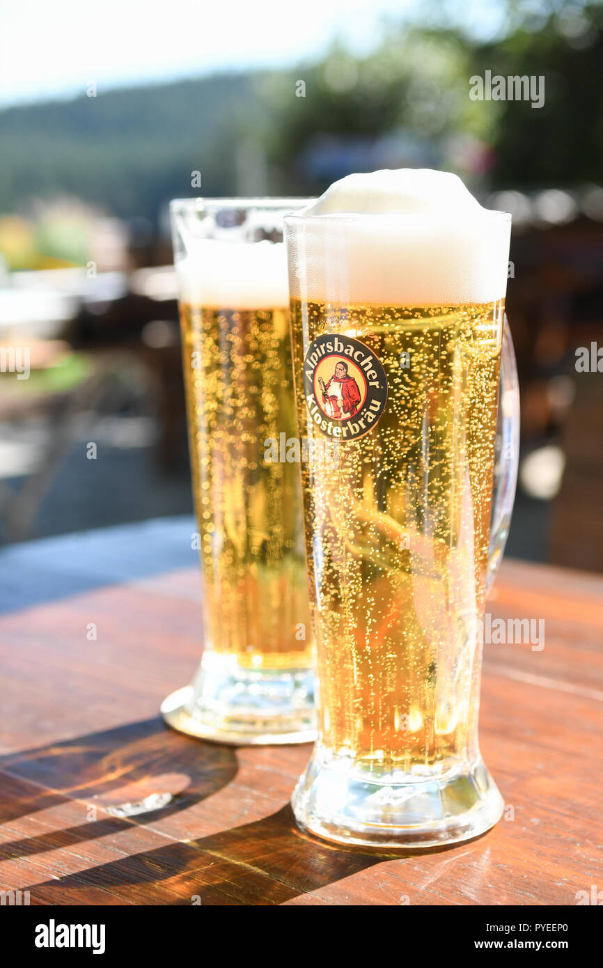 German beer - Alpirsbacher Klosterbrau beer in branded beer glasses on outdoor table - black forest, Germany, Europe Stock Photo